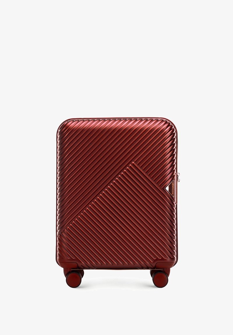 Valigia rigida con un motivo a coste di un rosso scuro lucido, caratterizzata da un design geometrico su un lato e quattro ruote per una facile mobilità.