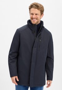 Granatowa wodoodporna kurtka z wysokim kołnierzem, zapięcie na guziki z przodu oraz kieszenią na zamek na klatce piersiowej. Gładka faktura, casualowy styl i długość do połowy.
