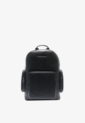 Sac à dos en cuir noir avec une poignée supérieure, une poche zippée à l'avant, deux poches latérales zippées et le logo "MOMODESIGN" sur le devant supérieur.
