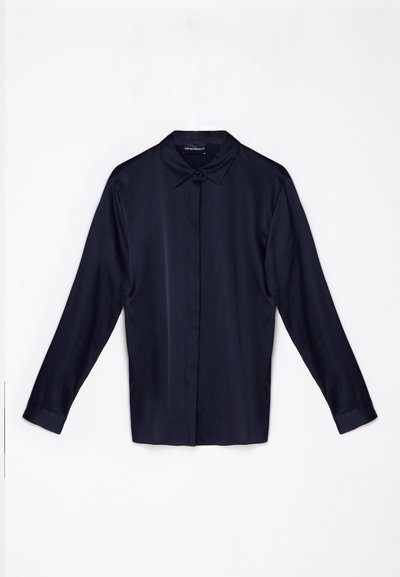 Camicia lunga a maniche con colletto classico in un tessuto liscio di un blu navy scuro, con chiusura frontale a bottoni e polsini abbottonati.