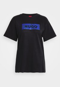 Černé tričko z bavlny s modrou texturovanou logem HUGO na obdélníkové nášivce. Krátké rukávy a kulatý výstřih.