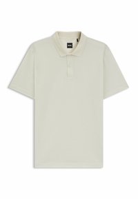 Ljusbeige polo skjorta i texturerad kvalitet. Har en klassisk krage och treknappslå. Korta ärmar med rak fåll.