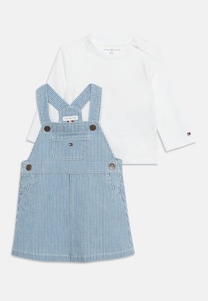 Chemise bébé à manches longues blanche avec robe salopette en denim rayé bleu et blanc, dotée d'une poche avant et de bretelles à boutons.