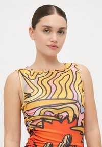 Top senza maniche in un vivace arancione, giallo e rosa con motivi astratti ondulati. Presenta un design arricciato lungo i fianchi e una texture liscia.