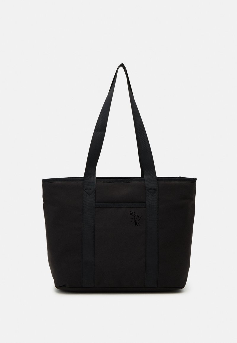 Sac cabas noir avec longues anses, poche avant et détail subtil de texte "recycle" sur fond clair uni.