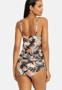 Ensemble de maillot de bain noir à fleurs comprenant un haut de tank avec des bretelles ajustables et un bas taille haute. Les motifs incluent des fleurs rouges et des feuilles vertes.