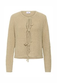 Smėlio spalvos pūkuotas megztinis su apvalia kaklo linija, ilgomis rankovėmis ir priekyje surišamu užsegimu. Tekstūruota medžiaga su minkštu, purus paviršiumi.