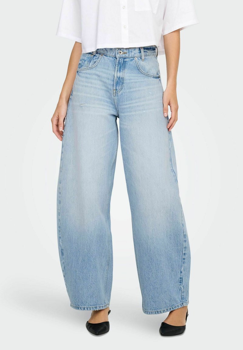 Ljusblå vida jeans gjorda av denim, med hög midja, blekt utseende och fem fickor, kombinerat med en vit skjorta.