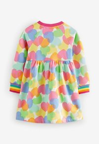 Langdurige jurk met een kleurrijk hartpatroon in pasteltinten, met een gathered taille en geribde manchetten in regenboogkleuren. Zachte katoenmaterialen.
