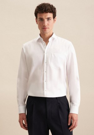 Weißes Langarmhemd aus glattem Stoff, mit kleinem Kragen, einer Brusttasche und dezenten Knopfdetails an der Vorderseite.