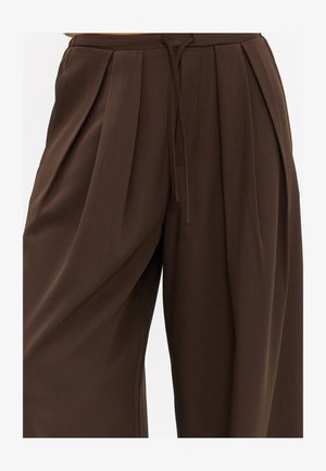 Pantalon plissé marron taille haute avec jambes larges et taille à cordon sur le devant.