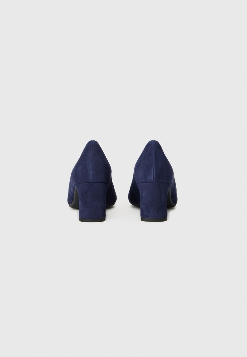 Chaussures à talons bloc en suède navy, vue en angle montrant l'arrière, avec une finition lisse et un design à bout pointu sur fond neutre.