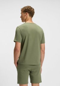 Olive green short-sleeve t-shirt with a crew neck, made of soft fabric, paired with matching shorts, displaying a simple design.