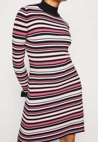 Vestito a maglione a costine con strisce orizzontali in rosa, nero e bianco, maniche lunghe e colletto alto. Il tessuto testurizzato offre elasticità.
