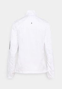 Chaqueta blanca con cuello alto, mangas largas y una textura suave y mate. Incluye un pequeño acento negro cerca del cuello.