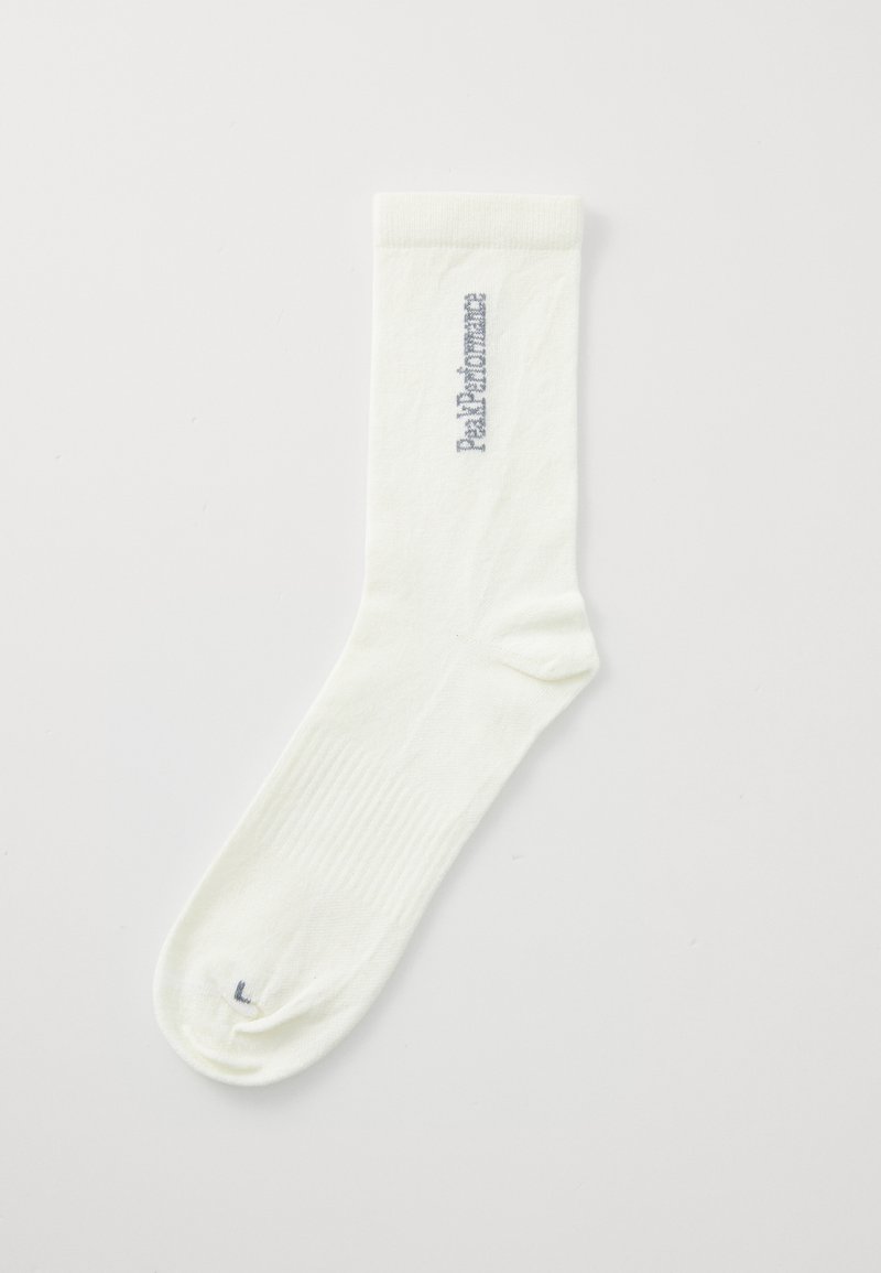 Witte katoenen sok met ribgebreide boord, een gladde textuur en blauwe bedrukte tekst "Paltom" langs de zijkant. Afgeronde teen en een minimaal ontwerp.