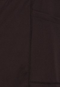 Schwarzer Sportstoff mit glatter Textur, mehreren Nählinien und einer kleinen Seitentasche, die in das Design integriert ist.