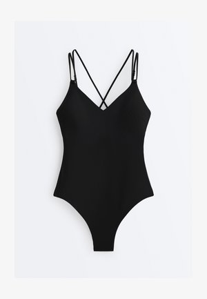 Maillot de bain noir une pièce avec décolleté plongeant et fines bretelles croisées, présenté à plat sur un fond blanc.