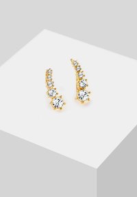 Boucles d'oreilles en or présentant un design dégradé avec plusieurs pierres en cristal transparent, mettant en valeur une forme élégante et allongée ainsi qu'une finition scintillante.