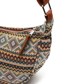 Borsa in tessuto stampato con forma arrotondata. Presenta disegni geometrici multicolori, una tracolla in pelle marrone e una cerniera argentata.