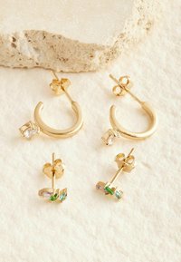 Guld hoops og stud øreringe med klare og farverige ædelstene. Glat finish med en skinnende overflade.