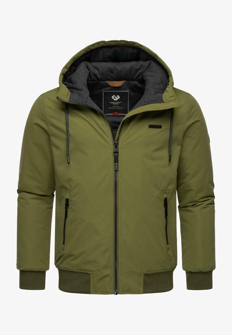Chaqueta acolchada color verde oliva con capucha, cierre frontal con cremallera, dos bolsillos laterales y puños elásticos. El forro interior presenta una textura gris oscura.