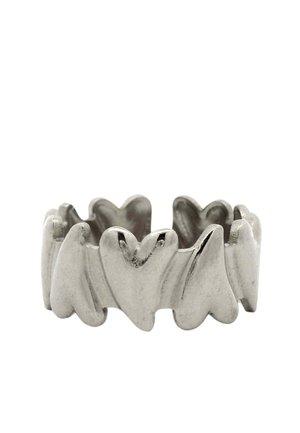 Anello d'argento con forme di cuore collegate che formano una fascia continua su sfondo bianco.
