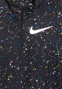 Schwarzes Sportoberteil mit mehrfarbigem gesprenkeltem Muster, ausgestattet mit einem Viertel-Reißverschluss und einem reflektierenden Nike-Logo auf der linken Brust.