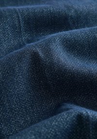 Tessuto denim di un profondo blu navy con una trama sottile. Aspetto morbido e leggermente lucido con un'intrecciatura complessa e una finitura liscia.