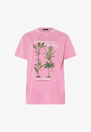 T-shirt rose à manches courtes avec des illustrations botaniques de banane, d'ananas, de gingembre torche et de palmier, étiqueté "Botanical Palms Bahia, Brésil."