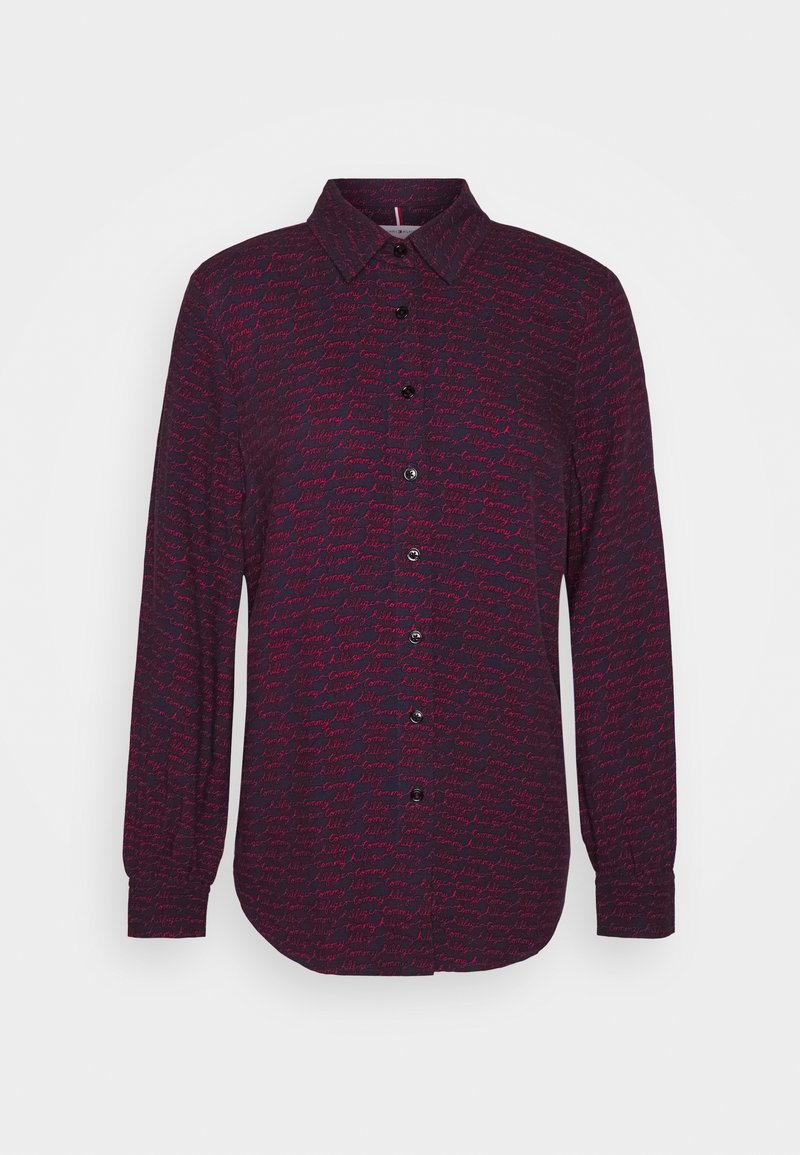 Long-sleeve button-up shirt in dark purple with a repeating pink handwritten pattern. Collared, with black buttons and cuffed sleeves.
