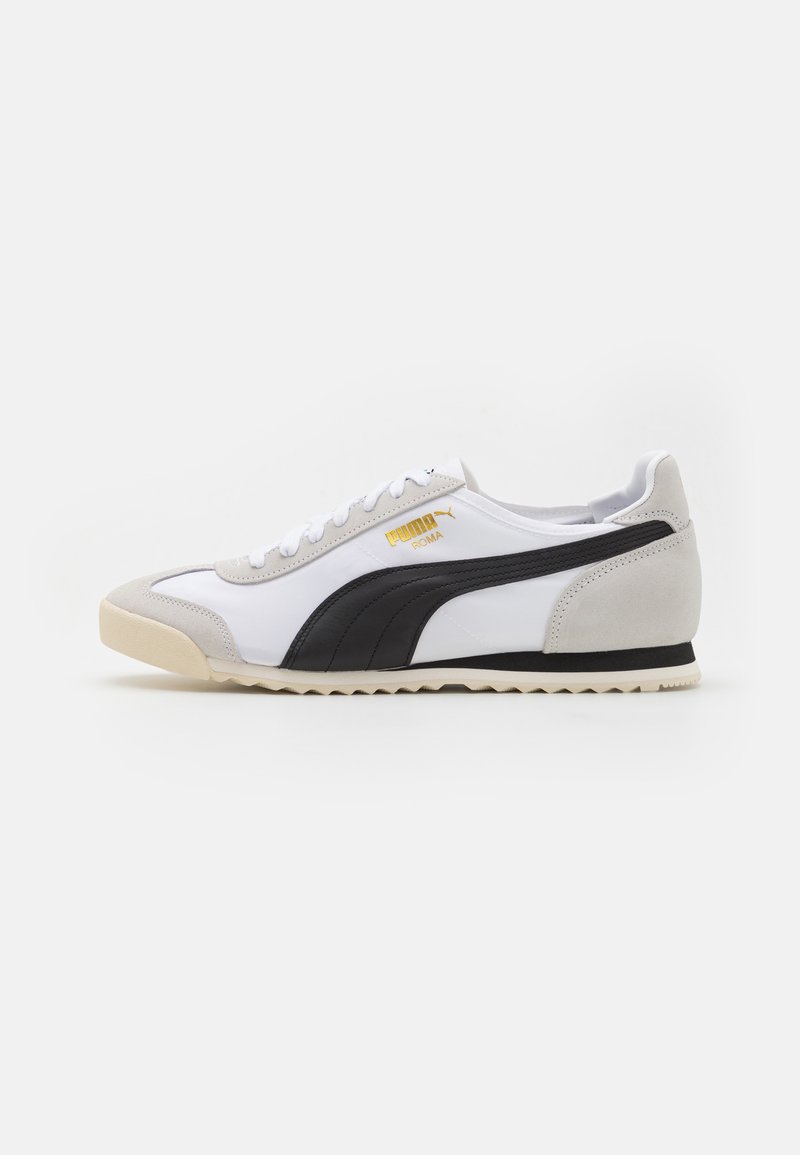 Baskets Puma Roma blanches et grises avec bande noire, semelle beige, lacets blancs et logo doré sur le côté, vues de profil sur fond blanc.
