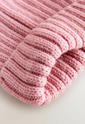Rosa gestrickte Mütze mit geripptem Muster. Weiche, dicke Wolle sorgt für einen engen Sitz. Das umgeschlagene Design verleiht dem Gesamtbild Tiefe und Detail.