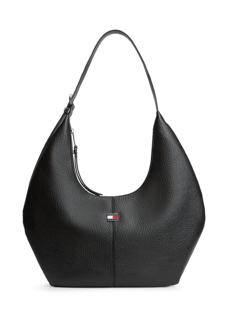 Sac à bandoulière en cuir noir texturé avec une sangle unique, fermeture éclair et petit logo rectangulaire de drapeau au centre avant.