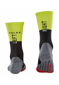 Chaussettes noires et jaunes vives avec des étiquettes imprimées "Gauche" et "Droite", texture lisse, talons gris renforcés et accents rouges.