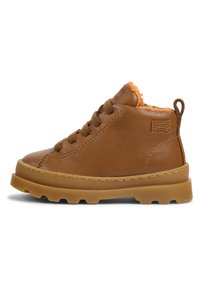 Bottes chelsea en cuir marron avec une finition texturée, ornées d'une doublure en fourrure orange, d'un bout rond et d'une semelle en caoutchouc épaisse. Design à lacets avec une languette arrière.