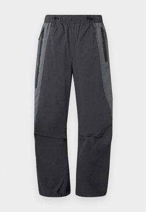 Σκούρο γκρι και μαύρο παντελόνι πεζοπορίας με ελαστική μέση και φερμουάρ σε πλαϊνές τσέπες, σχεδιασμένο για υπαίθριες δραστηριότητες.