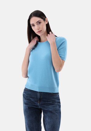 Maglione azzurro chiaro a maniche corte realizzato in un morbido tessuto testurizzato, con scollatura rotonda e orlo a costine, abbinato a jeans scuri.