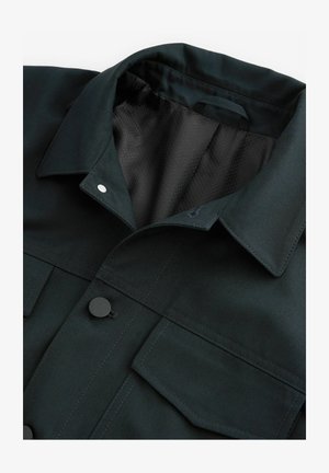 Sort denimjakke med en struktureret krave, trykknapper og to brystlommer. Indersiden har et tekstureret mesh-for.