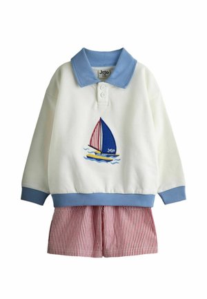 Valge pikemate varrukatega särk sinise krae ja varrukaservadega, millel on purjekala tikand, sobitatud punaste ja valgete triibuliste pükstega.