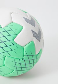 Zelený a bílý házenkářský míč s texturovaným povrchem, geometrickými vzory a šitým designem se šedými akcenty.
