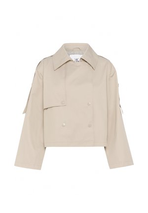 Veste beige courte avec un large col, des boutons argentés à double boutonnage et des épaulettes ; fabriquée en tissu lisse et léger.