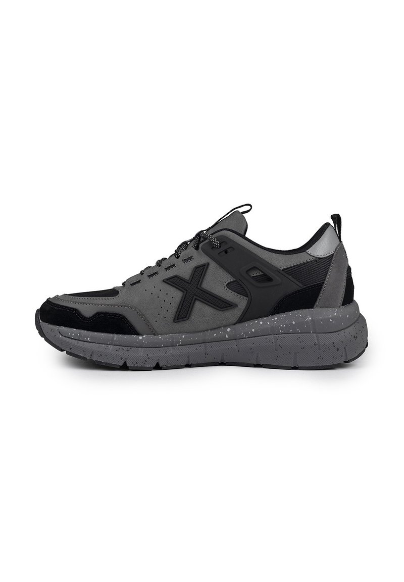 Baskets de sport grises avec des accents noirs, en mesh respirant, en daim texturé et avec une semelle marbrée. Elles disposent de lacets ronds et d'un col rembourré.