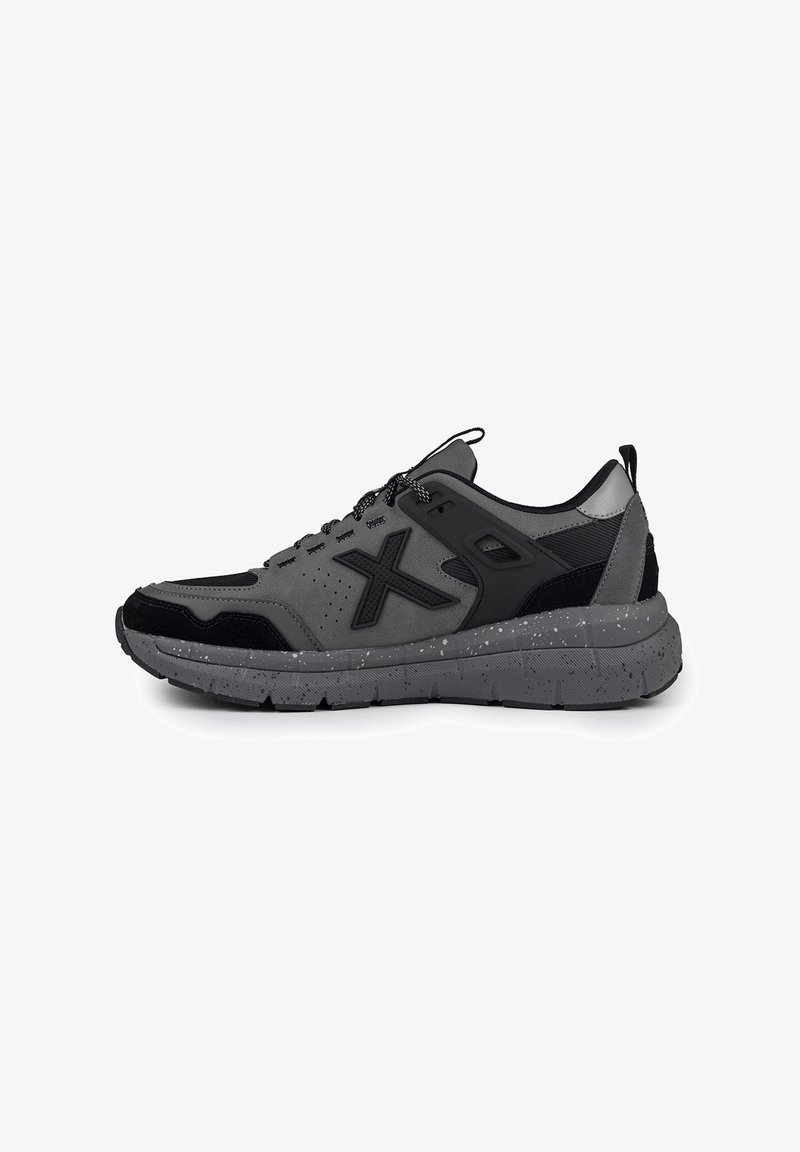 Baskets de sport grises avec des accents noirs, en mesh respirant, en daim texturé et avec une semelle marbrée. Elles disposent de lacets ronds et d'un col rembourré.