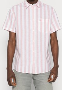 Camicia a maniche corte con bottoni, in strisce verticali rosa e bianche, dotata di colletto, taschino frontale e tessuto leggero.