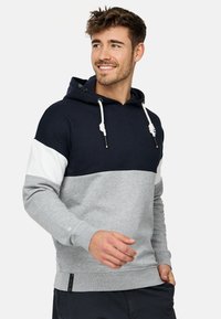 Hætte sweatshirt i marineblå, hvid og grå. Fremstillet af blødt stof med et farveblok design, der har snører og et logotag i kanten.