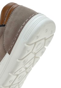 Graue Wildledersneaker mit braunen Lederakzenten, ausgestattet mit einer weißen Gummisohle mit strukturiertem Grip und hexagonalen Mustern.