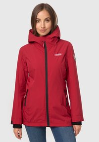 Chaqueta impermeable roja con cremallera frontal, capucha ajustable, detalles en negro y bolsillos laterales. Presenta un logo en la parte izquierda del pecho.