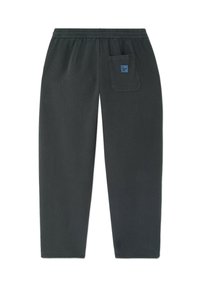 Čierne elastické nohavice v páse s pravou zadnou vreckom, na ktorom sa nachádza malá modrá štvorcová nálepka s textom.