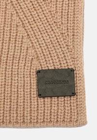 Beige strikket tørklæde med ribbet tekstur, udstyret med et sort rektangulært lædermærke prægede med "ALLSAINTS", der er fastgjort til kanten.